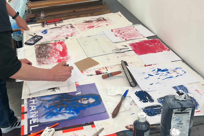 Arbeitsplatz im Zeichenzimmer mit Farben, Papier u.a. Materialien zum Drucken