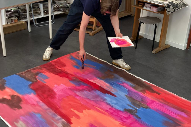 Kursteilnehmer bemalt eine große Leinwand