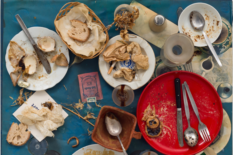 Eine blaue Tischdecke mit vielen Tellern und Essensresten.